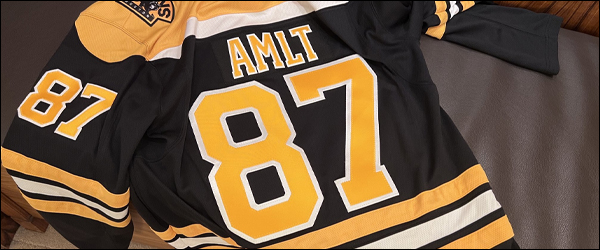 Bannière d'illustration : un maillot des Bruins où est noté AMLT et 87